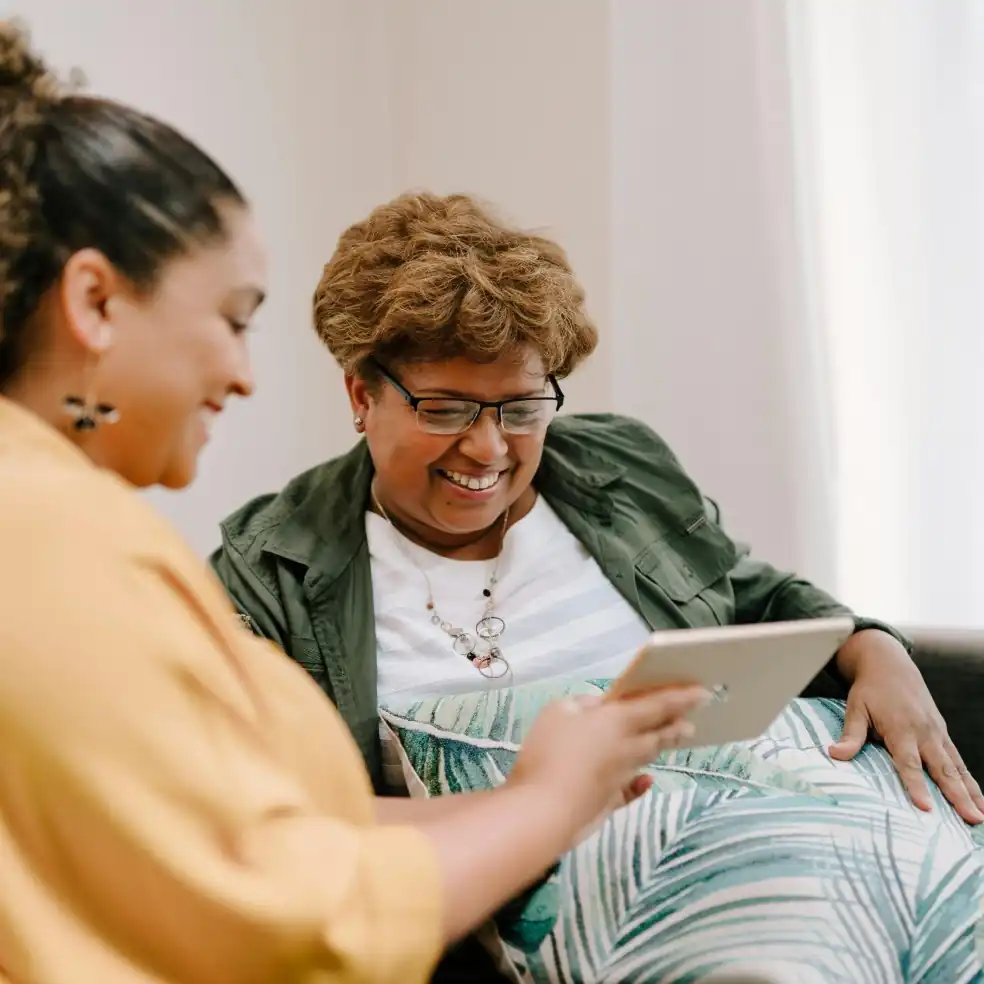 Dos señoras sonriendo usando una tablet